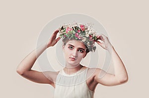 Portrait of a young girl in a wreath of roses