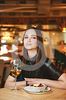 Portrait of young gorgeous woman drinking champagne in a glass and looking with smile, eating ice cream fruit dessert.