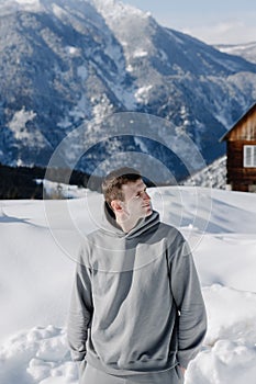 Portrait of a young guy against the backdrop of snow-capped mountains. photo