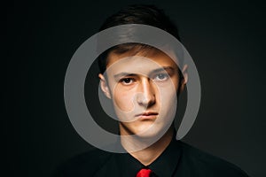 Portrait young guy on a dark studio