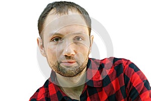 Portrait of a young guy in a red plaid shirt on a white background. The face of a cute, hairy man. Male portrait of isolate