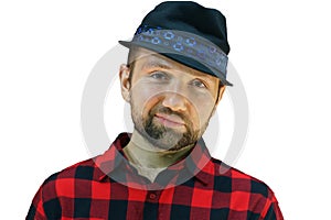 Portrait of a young guy in a red plaid shirt on a white background. The face of a cute, hairy man. Male portrait of isolate