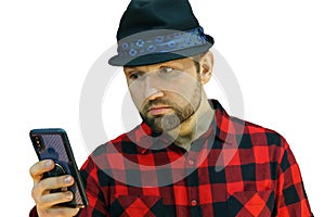 Portrait of a young guy in a red plaid shirt on a white background and with a phone in his hands. A bearded man looks at the phone