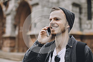 The portrait of a young guy talking on the phone