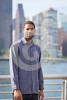 Portrait of young handsome African American man with NYC skyline