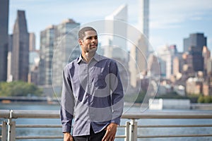 Portrait of young handsome African American man with NYC skyline