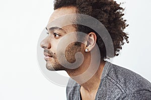 Portrait of young handsome african man in profile over white background.