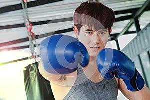 Portrait of a young handsome asian man practicing boxing