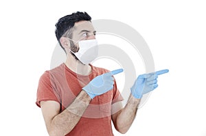 Portrait of young handsome beautiful man with face mask and blue gloves pointing side on copy space. 2019-nCoV.