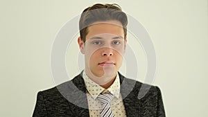 Portrait of young handsome businessman in suit with tie on white background