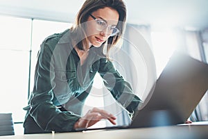 Portrait of Young handsome businesswoman using laptop computer at modern office.Blurred background.