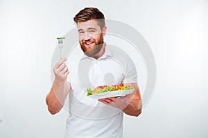 Portrait of a young handsome casual man eating salad