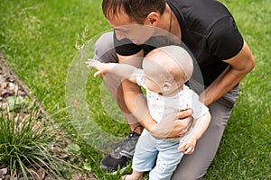 Portrait of young handsome father holding his adorable cute newborn baby boy. Lifestyle. Real people. Fatherhood and