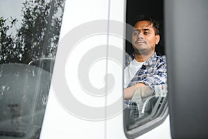 Portrait of a young handsome Indian truck driver. The concept of logistics and freight transportation.