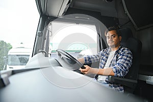 Portrait of a young handsome Indian truck driver. The concept of logistics and freight transportation.