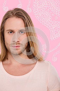 Portrait of young handsome man against pink background