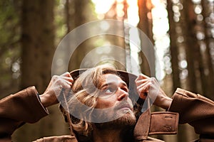 Portrait of a young handsome man, with a mysterious look, in a dark wild forest.