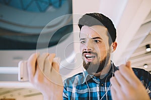 Portrait of a young handsome man with phone and headphones in ur