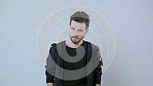 Portrait of young handsome man posing on white background,the guy is wearing a black jacket and t-shirt