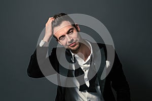 Portrait of a young handsome man in a suit, bow tie and shirt bu