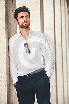 Portrait of young handsome man in white shirt outdoor.