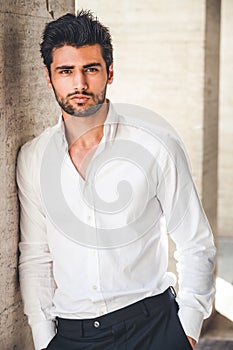 Portrait of young handsome man in white shirt outdoor.