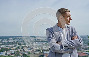 Portrait of young handsome serious businessman on city background