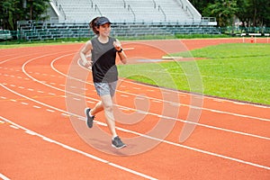 Portrait of young happiness athlete runner woman running in the running track in stadium.