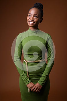 Portrait of young happy African Zulu businesswoman thinking