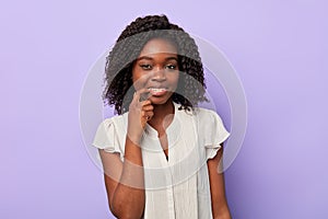 Portrait of a young happy afro woman pointing to her teeth