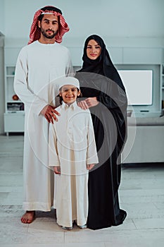 portrait of young happy arabian muslim family couple with son in traditional clothes spending time together during the