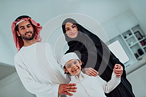 portrait of young happy arabian muslim family couple with son in traditional clothes spending time together during the