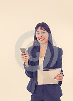 Portrait of a young happy attractive business woman checking emails and texting on mobile phone