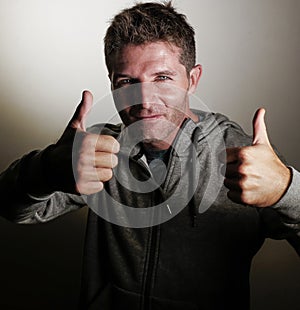 portrait of young happy and attractive sporty man on his 30s giving thumb up smiling cheerful and positive posing isolated on eve