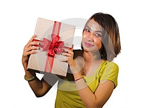 Portrait of young happy and beautiful Asian Indonesian woman holding Christmas present or birthday gift box with red ribbon