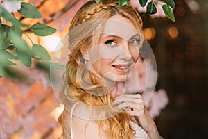 Portrait of young happy beautiful blonde woman in white vintage dress. Girl laughs smile on face. Studio background