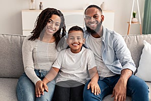 Portrait of young happy black family smiling at home