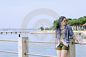 Portrait of young happy brunette woman in sunglasses relaxing at the seaside, beach at Adriatic sea. Summer vacation. Travel