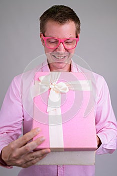 Portrait of young happy businessman opening gift box