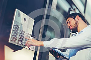 Portrait of a young happy businessman outside the office building, enters the building