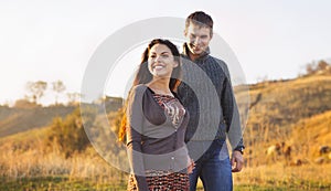 Portrait of young happy couple laughing in a cold day by the sea