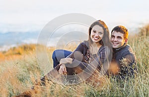 Portrait of young happy couple laughing in a cold day by the sea