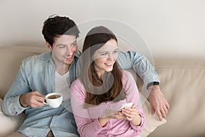 Portrait of young happy couple relaxing indoors, enjoying coffee