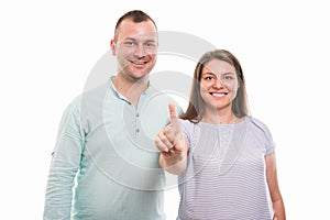 Portrait of young happy couple showing number one with finger