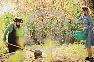 Portrait of a young happy couple in yard during spring season. Happy Couple Farmers working with spud on spring field.