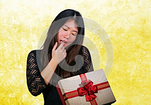 portrait of young happy and excited beautiful Asian Chinese woman receiving a romantic anniversary gift box holding the