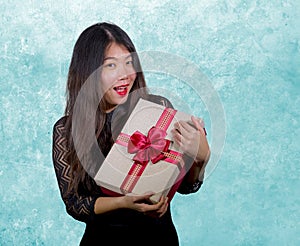 portrait of young happy and excited beautiful Asian Japanese woman receiving a romantic anniversary gift box holding the