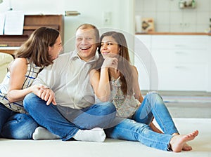 Portrait of young happy family with pretty teenager daughter having fun together at home