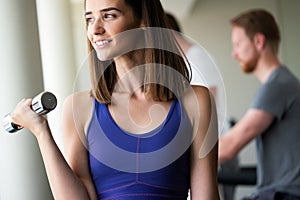 Portrait of a young happy fit woman with dumbbells