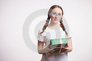 Portrait of a young happy girl holding her gift for new year or birthday.